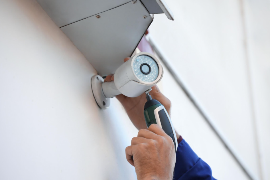A guy installing a wall mounted cctv